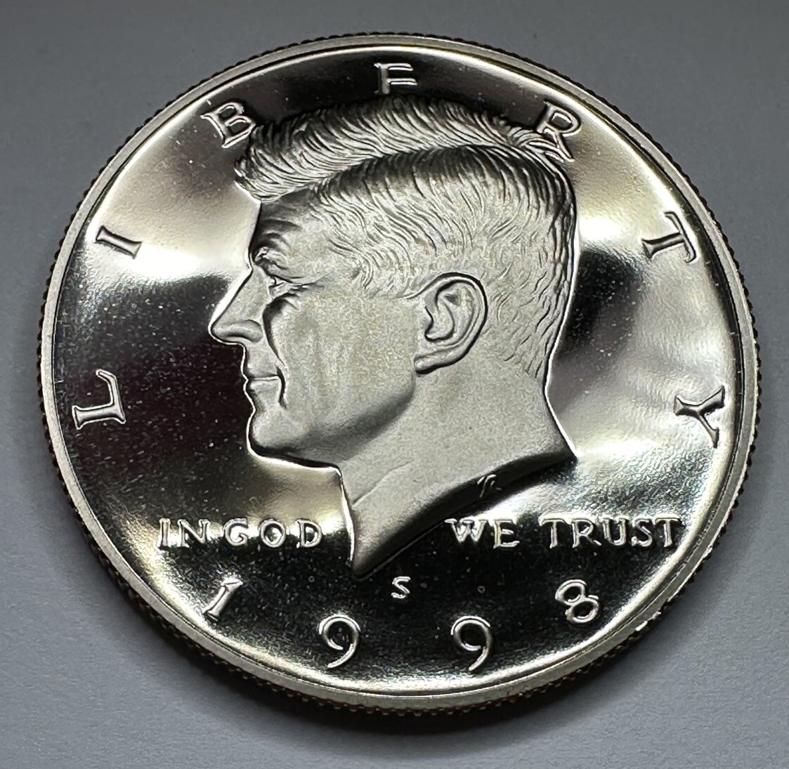 1998-S proof Kennedy half dollar clipped planchet error showing a curved section missing from the coin edge